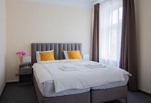 a bedroom with a large bed with yellow pillows at Laima V. Apartments in Riga