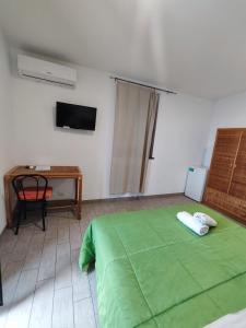 a bedroom with a green bed and a desk at Hotel Faraglione in Vulcano