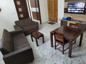 een woonkamer met een bank en een tafel bij Castle Hebbal Service Apartments in Bangalore