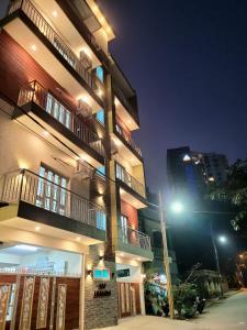 wysoki budynek z światłem ulicznym przed nim w obiekcie Castle Hebbal Service Apartments w mieście Bengaluru