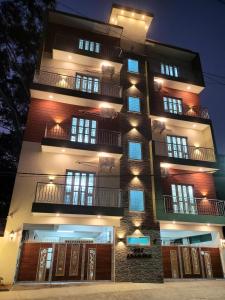 Un grand bâtiment avec des lumières allumées la nuit dans l'établissement Castle Hebbal Service Apartments, à Bangalore