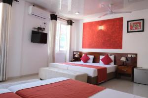 a bedroom with two beds and a red painting on the wall at My City Hotel in Kandy