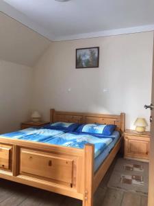 Schlafzimmer mit einem großen Holzbett mit blauer Bettwäsche in der Unterkunft Apartmaji Misotič in Gozd Martuljek