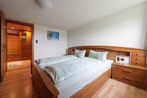 um quarto com uma cama grande e uma cabeceira em madeira em Ferienwohnung Raid em Riefensberg