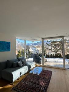 a living room with a couch and a large window at THE VIEW - Modern Panorama Residence in Bad Ischl