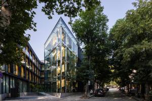 a glass building on a street with trees at Glarros OldTown in Tbilisi City