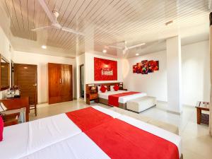 a large bedroom with two beds and a desk at My City Hotel in Kandy