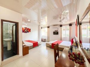 a bedroom with two beds and a table and a sink at My City Hotel in Kandy