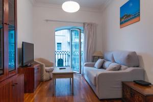 a living room with a couch and a tv at Apartamento con vistas a la playa de la Concha en Donostia-San Sebastián - Marina 1 in Donostia-San Sebastián +18 photos