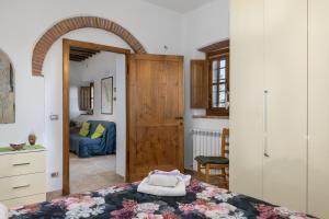 a bedroom with a bed and a door to a room at Casa Ernesto - porzione di colonica in Monteriggioni