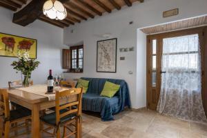 a living room with a blue couch and a table at Casa Ernesto - porzione di colonica in Monteriggioni