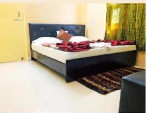 Hotel Anmol & Restaurant, Rudraprayag في Rudraprayāg: غرفة نوم مع سرير مع اللوح الأمامي الأسود