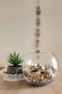 a glass bowl filled with shells on top of a table at Bec's Beach House Getaway in Batemans Bay