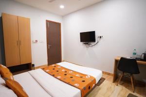 een slaapkamer met een bed, een bureau en een televisie bij Hotel Lyf Corporate Suites - Peera Garhi in New Delhi