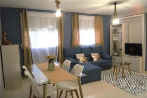 ein Wohnzimmer mit einem blauen Sofa und einem Tisch in der Unterkunft Rose in Córdoba