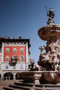 une fontaine dans une ville avec un bâtiment en arrière-plan dans l'établissement Hotel Venezia, à Trente