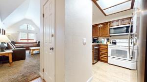 a kitchen and living room with a stove top oven at Aspen Creek #311 condo in Mammoth Lakes