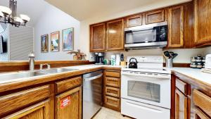 a kitchen with wooden cabinets and white appliances at Aspen Creek #311 condo in Mammoth Lakes