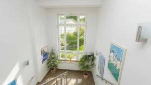 an empty hallway with a window and plants at Hotel garni Arte Vita in Heringsdorf