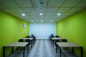 a room with tables and chairs and a white screen at Hotel Lyf Corporate Suites - Peera Garhi in New Delhi