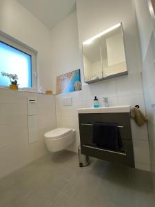 bagno bianco con servizi igienici e lavandino di Schöne, moderne Wohnung mit großzügiger Terasse a Essen