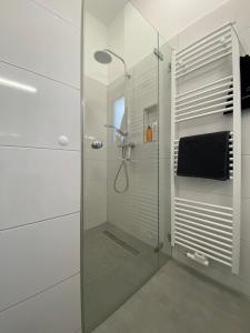una doccia con porta in vetro in bagno di Schöne, moderne Wohnung mit großzügiger Terasse a Essen