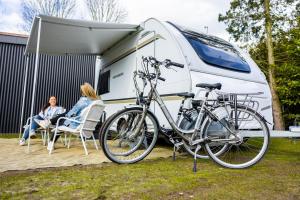 una bicicleta estacionada frente a una caravana en TOP Spa 2+2 en Voorthuizen