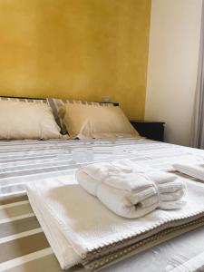 Una cama con toallas blancas encima. en Benaco Village Home, en Toscolano Maderno