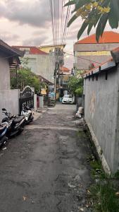 eine Gasse mit Autos, die an der Straßenseite geparkt sind in der Unterkunft Rodin Bali Hostel in Seminyak