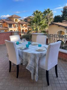 mesa con sillas blancas y mantel blanco en Benaco Village Home, en Toscolano Maderno