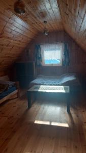 1 dormitorio con 1 cama en un ático de madera en Domek z Kominkiem Jaworzynka - Śliwkula, en Jaworzynka