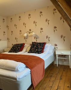 um quarto com duas camas e uma parede com flores em Hammenhögs gästgivaregård em Hammenhög