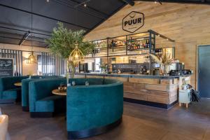 een restaurant met blauwe stoelen en een bar met een buffet bij TOP Spa 2+2 in Voorthuizen