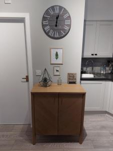 a large clock on a wall above a counter in a kitchen at Flat 6 Corner House in Doncaster