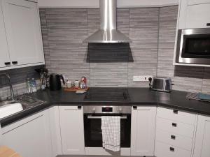 a kitchen with white cabinets and a stove top oven at Flat 6 Corner House in Doncaster