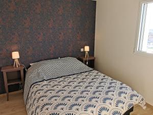 ein Schlafzimmer mit einem Bett und zwei Tischen mit Lampen in der Unterkunft L ancrage - proche de la plage in Brem Sur Mer