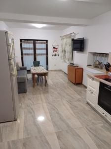 a kitchen and living room with a table and a refrigerator at Casa Ovidiu Rasnov in Râşnov +12 photos