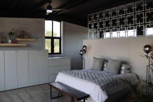 een slaapkamer met een bed en een bank erin bij LoftHill in Welkom