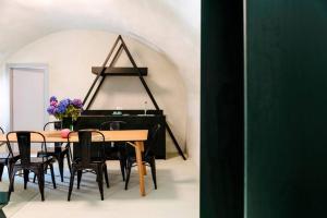 a dining room with a table and a piano at Casa Maer - casa d'artista in Lavenone