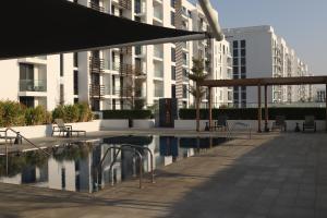 une terrasse avec des chaises et une piscine en face d'un bâtiment dans l'établissement 40 Minutes drive to Burj Khalifa, à Charjah