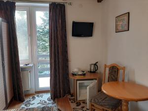 sala de estar con mesa y ventana en Guest House U Sester, en Skhidnytsya
