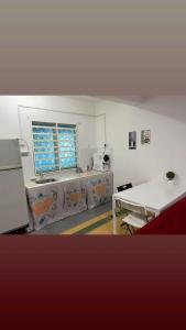 a kitchen with a table and a sink and a window at lost world of tambun muslim guest house in Ipoh