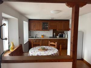 - une cuisine avec une table, une table et une table dans l'établissement La casa di famiglia, à Brusson