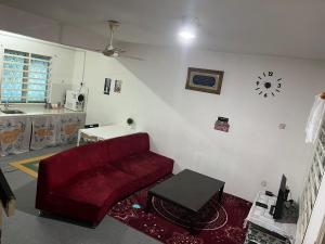 a living room with a red couch and a table at lost world of tambun muslim guest house in Ipoh