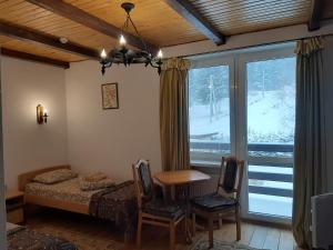 um quarto com uma cama, uma mesa e uma janela em Guest House U Sester em Skhidnitsa