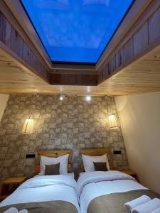 a bedroom with two beds with a large skylight at Berkri Gastro Yard & Guest House in Yenokavan