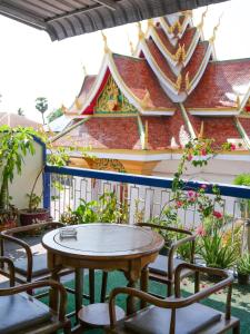 einen Tisch und Stühle auf einem Balkon mit einem Gebäude in der Unterkunft KFG Guesthouse in Thakhek