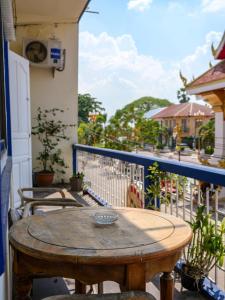 einen Holztisch auf dem Balkon eines Hauses in der Unterkunft KFG Guesthouse in Thakhek