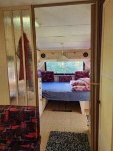 mały pokój z łóżkiem w pokoju w obiekcie Caravan at the Cottage House 