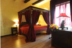 a bedroom with a canopy bed with red curtains at B&B Muro Torto Cairoli - Struttura sanificata giornalmente con prodotti specifici conformi al Decalogo del Ministero Salute - Personale sottoposto a test sierologico periodicamente in Foggia